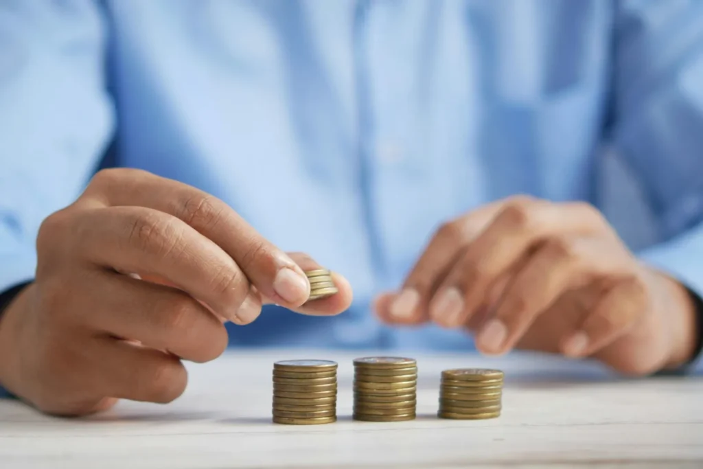 Person arranging coins into stacks on a table