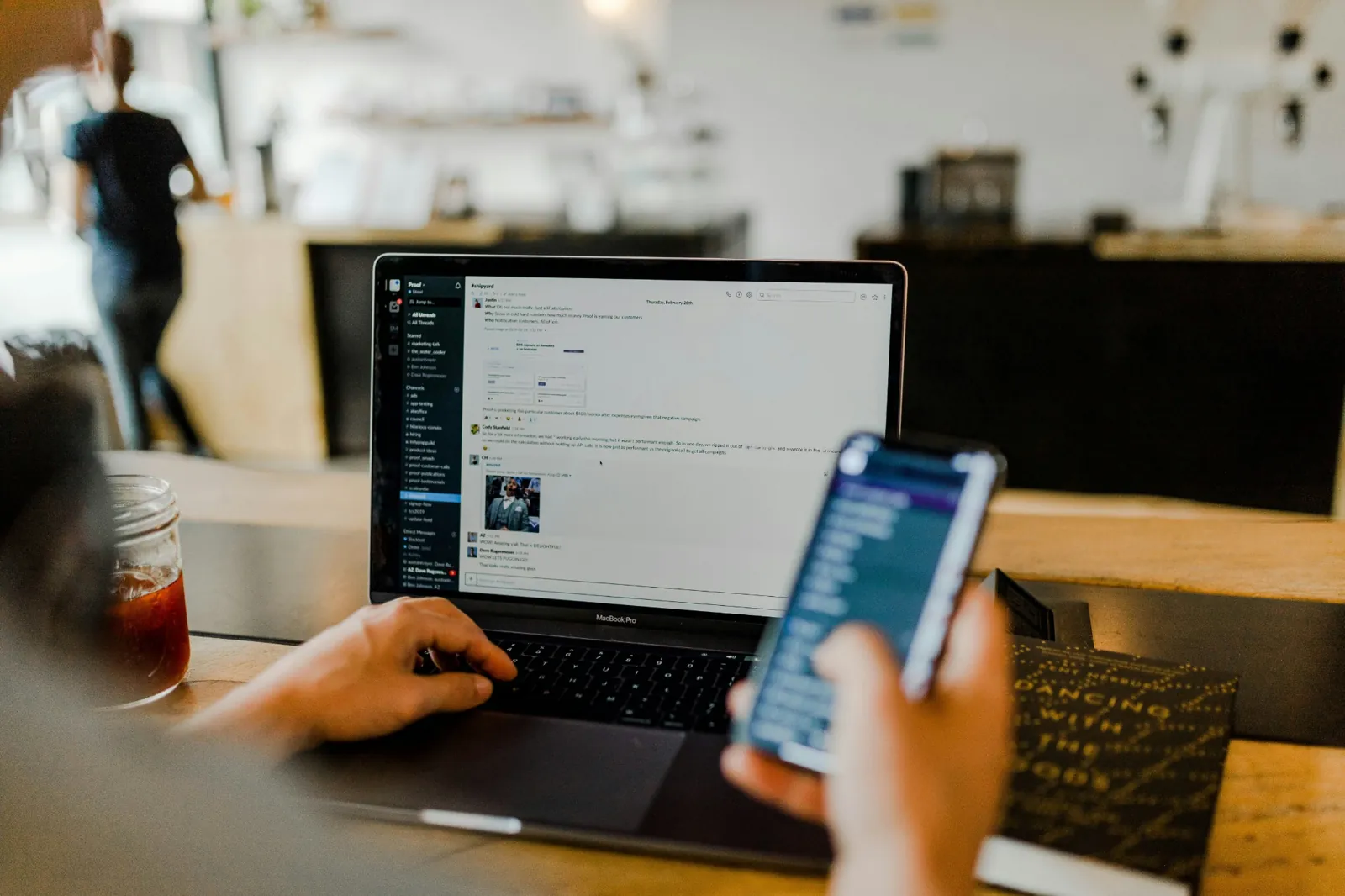 Person using a laptop and smartphone at a desk
