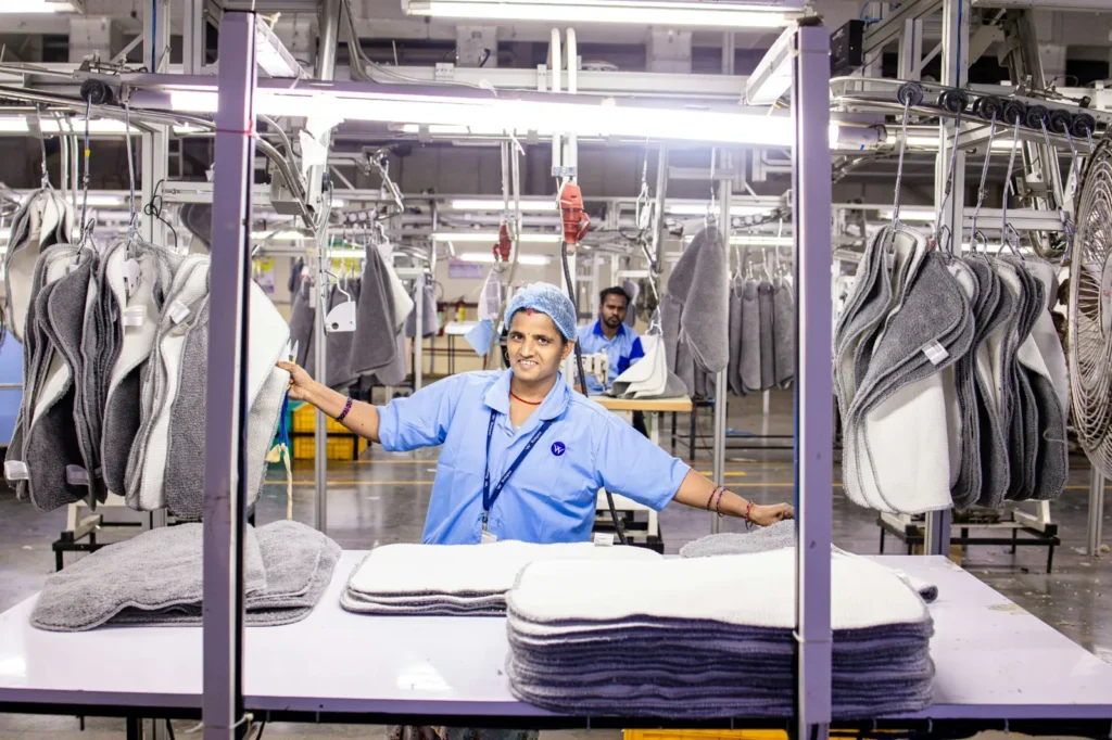 Worker standing beside equipment in an industrial laundry