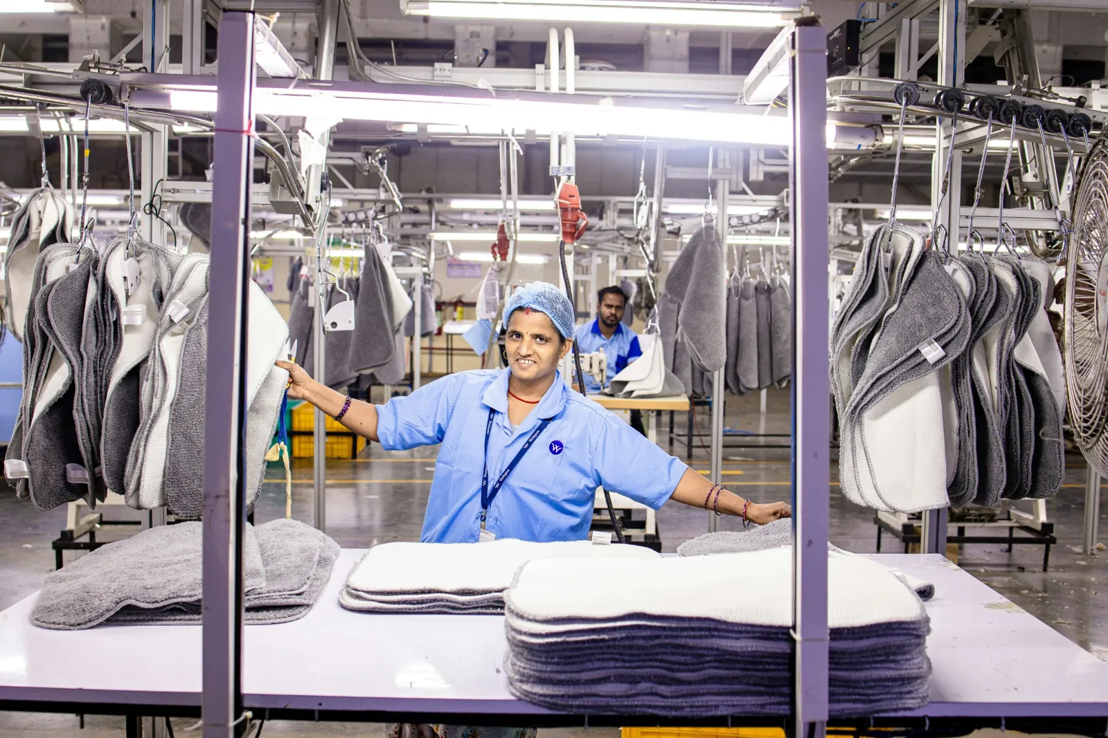 Worker standing beside equipment in an industrial laundry
