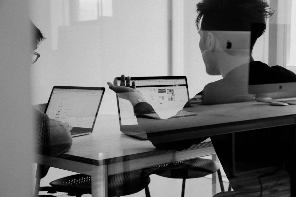 Black-and-white photograph of colleagues working with laptops