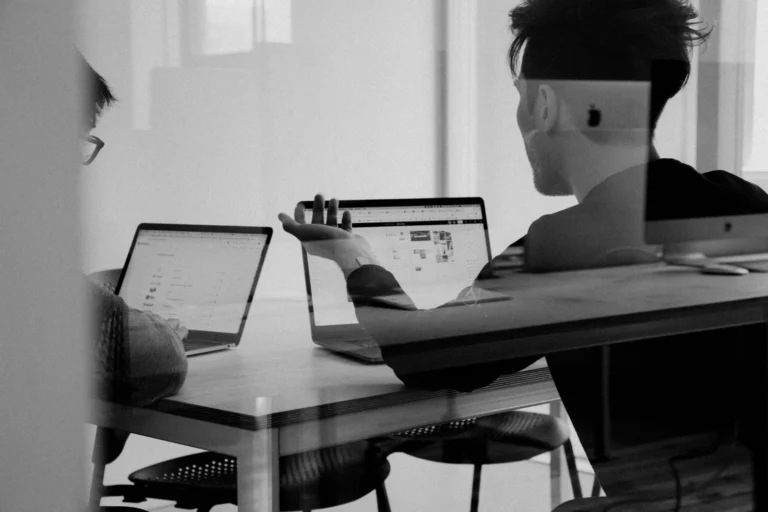 Black-and-white photograph of colleagues working with laptops