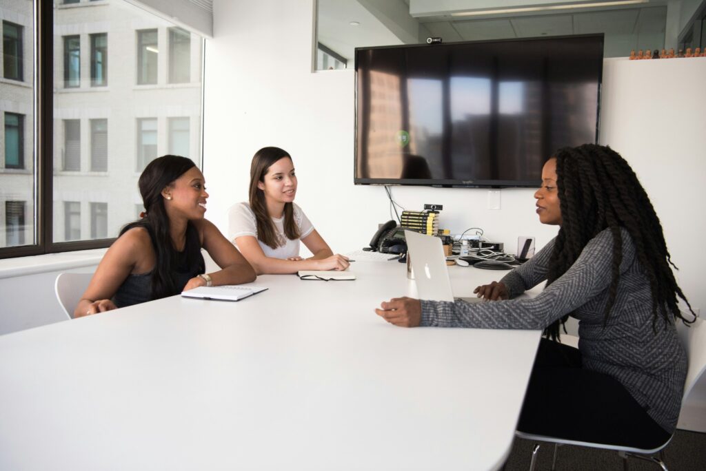Three colleagues talking around a meeting-room table