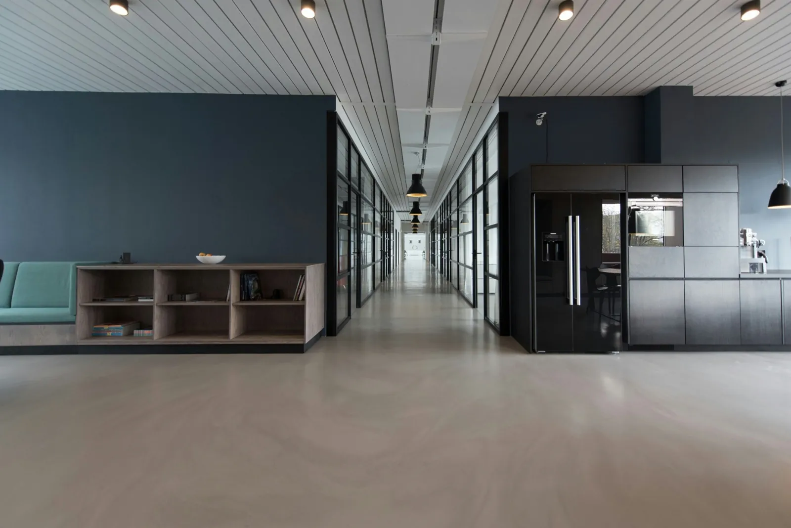 Empty meeting room beside a glass-walled office corridor