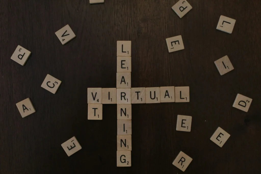 Wooden letter tiles spelling Virtual and Learning on a dark surface